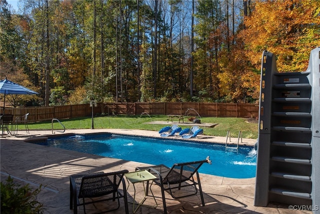 view of swimming pool with a yard, pool water feature, and a patio area