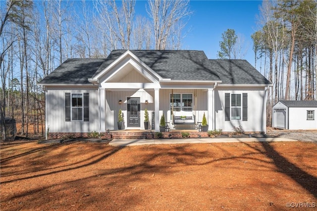 view of front of house featuring a porch, a storage unit, a front yard, and a garage