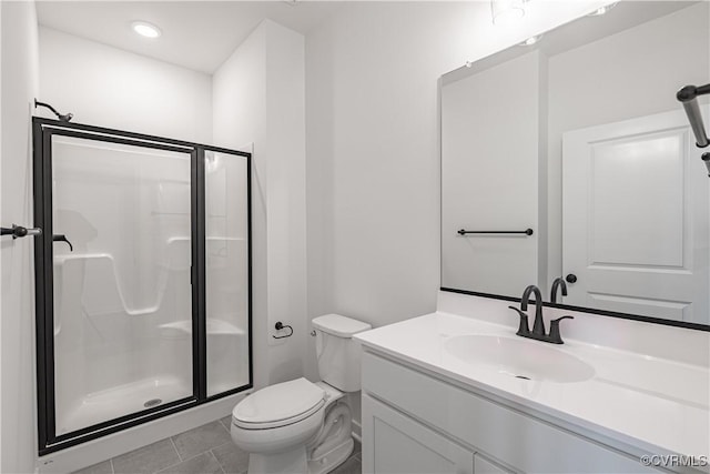 bathroom with vanity, tile patterned flooring, a shower with door, and toilet