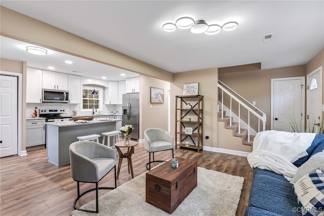 living room featuring hardwood / wood-style flooring and sink