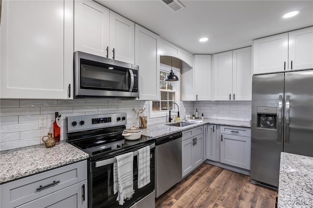 kitchen featuring pendant lighting, sink, stainless steel appliances, and white cabinets