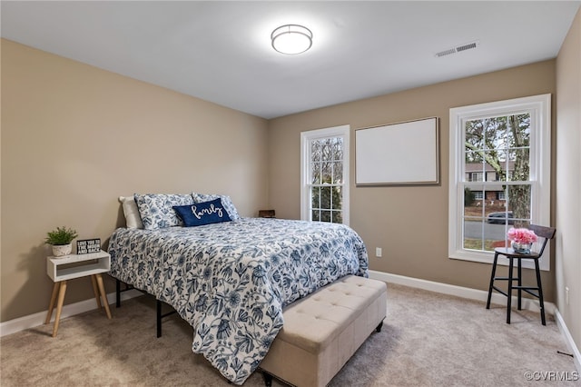 bedroom featuring light carpet and multiple windows