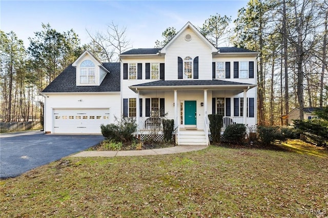 colonial inspired home featuring driveway, a garage, a front lawn, and a porch