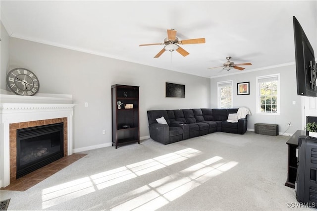 living room featuring baseboards, ornamental molding, a tile fireplace, and light colored carpet