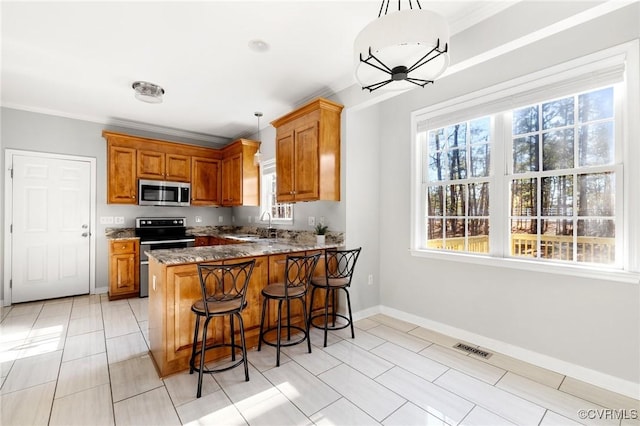 kitchen with stainless steel appliances, hanging light fixtures, a peninsula, and a sink