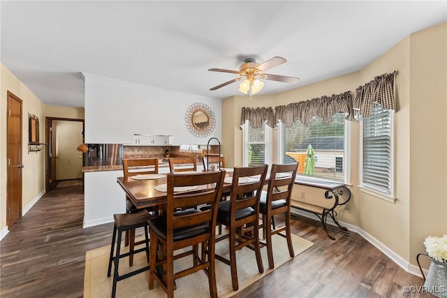 dining space with dark hardwood / wood-style flooring and ceiling fan