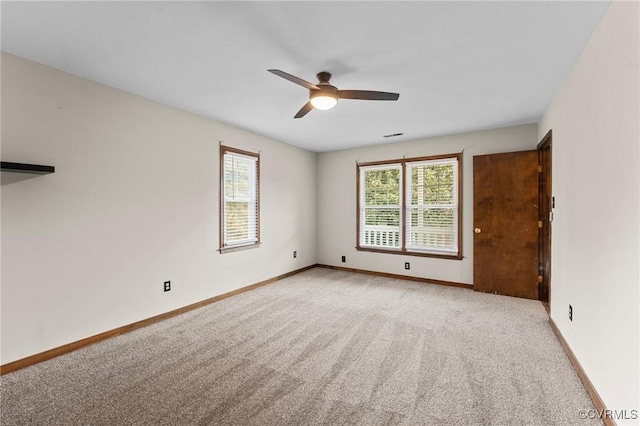 spare room with light colored carpet and ceiling fan