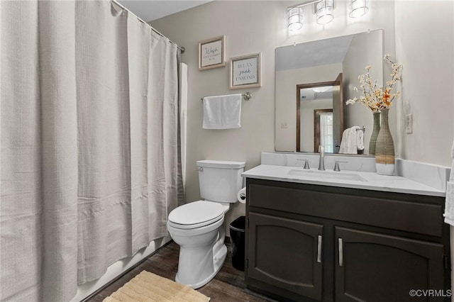 full bathroom with vanity, toilet, hardwood / wood-style floors, and shower / bath combo with shower curtain