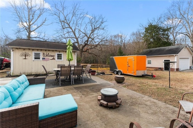 view of patio / terrace with a garage and an outbuilding