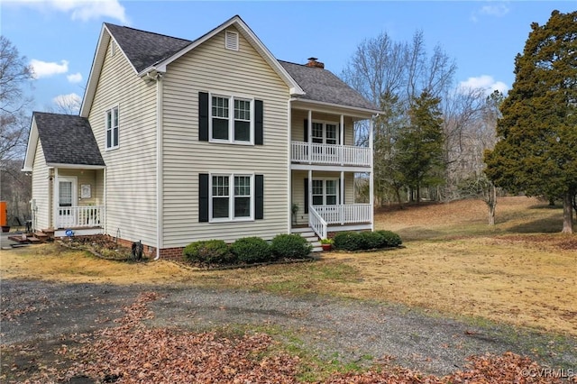 view of property featuring a balcony and covered porch