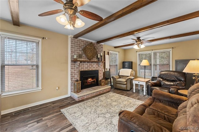 living room with a healthy amount of sunlight, dark hardwood / wood-style flooring, and a brick fireplace