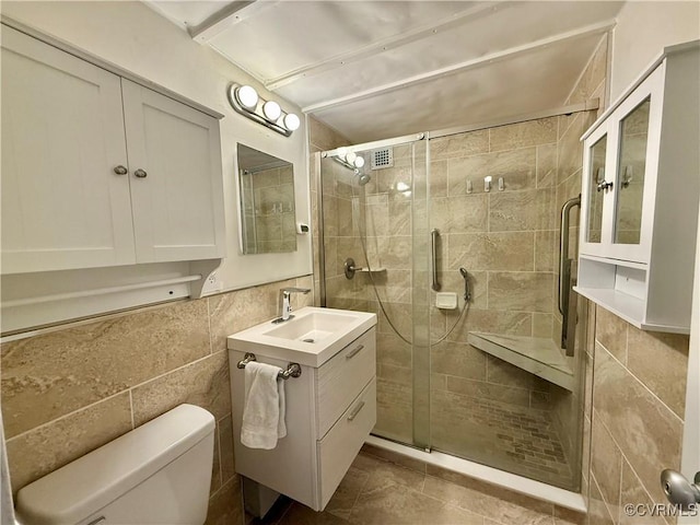 full bath with tile walls, a shower stall, toilet, and vanity