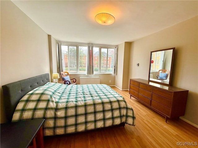 bedroom featuring baseboards and light wood-type flooring