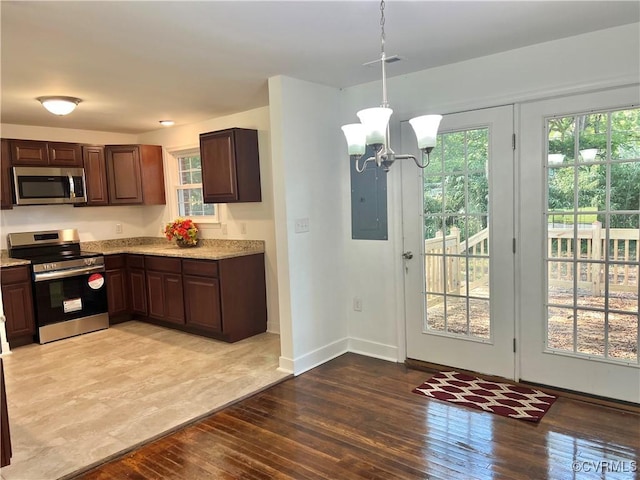 kitchen with wood-type flooring, hanging light fixtures, electric panel, stainless steel appliances, and an inviting chandelier