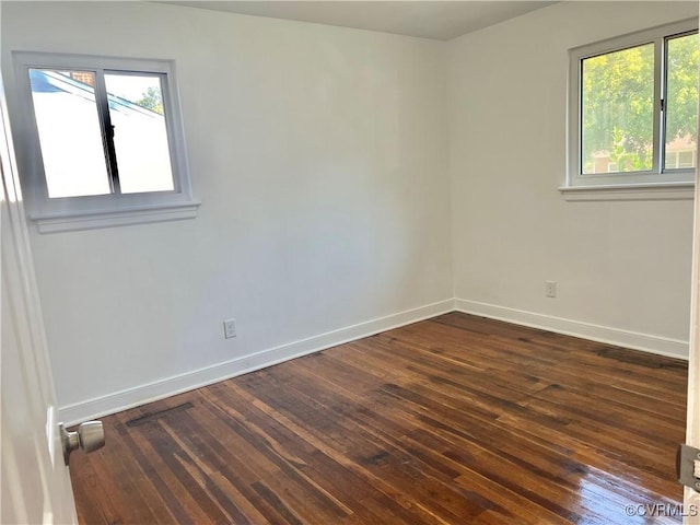 unfurnished room with a healthy amount of sunlight and dark hardwood / wood-style floors