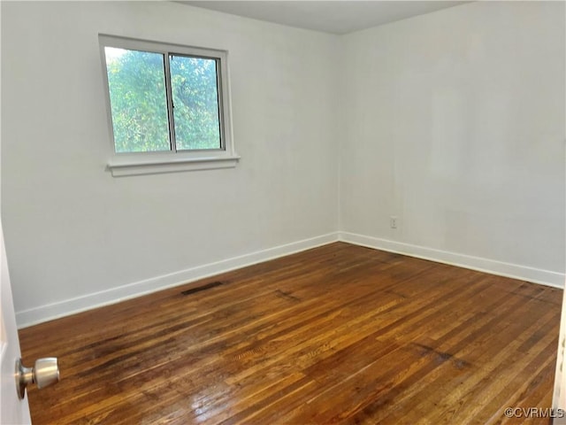 unfurnished room with dark wood-type flooring