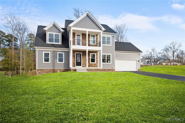 view of front of property with a garage, a front lawn, and a balcony