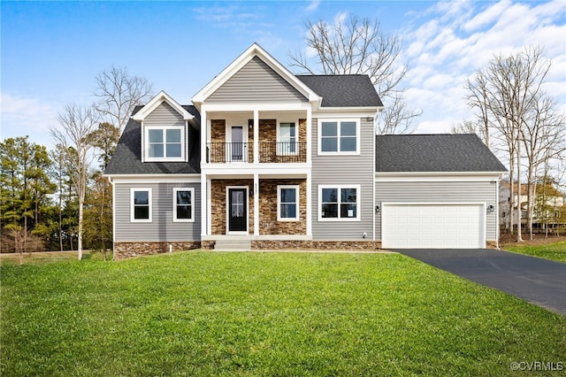 view of front of home featuring a garage, a balcony, and a front lawn