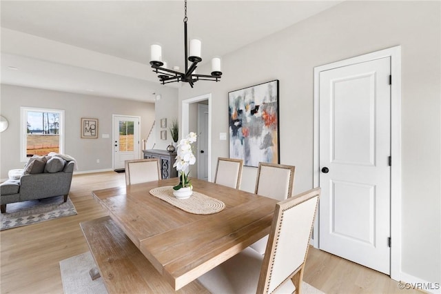 dining space featuring a notable chandelier and light wood-type flooring