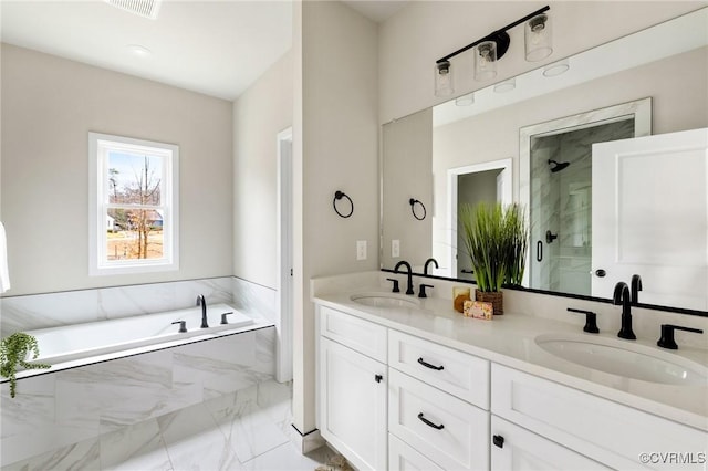 bathroom with vanity and shower with separate bathtub