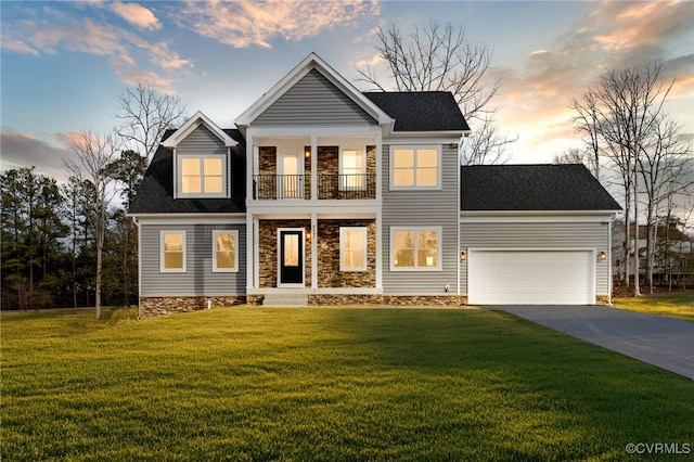 view of front of house with a garage, a balcony, and a yard