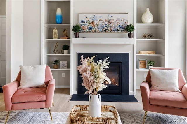 sitting room featuring hardwood / wood-style flooring and built in features