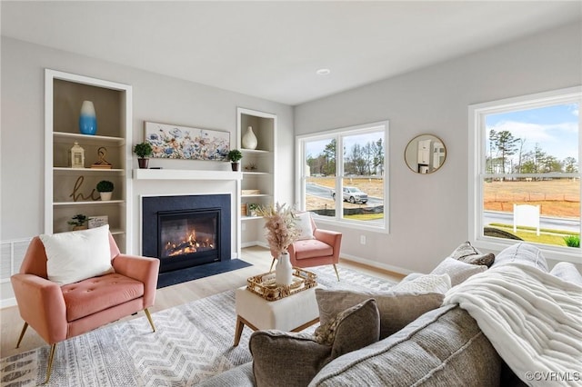 living room featuring light hardwood / wood-style floors and built in shelves