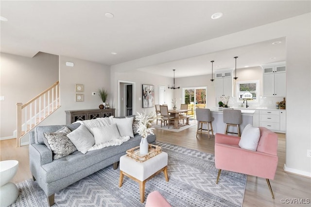 living room with a chandelier and light hardwood / wood-style floors