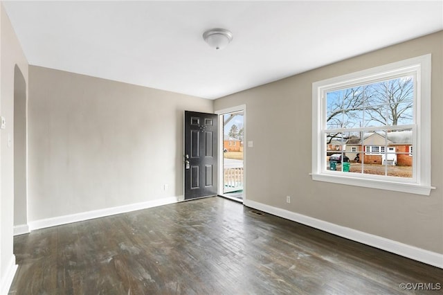 unfurnished room with dark wood-type flooring and a wealth of natural light