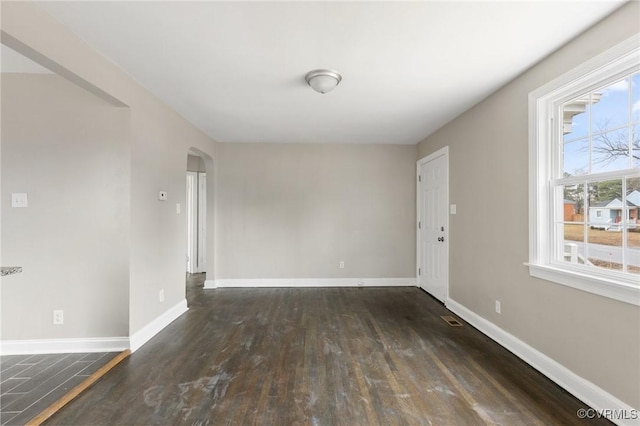 unfurnished room with dark wood-type flooring