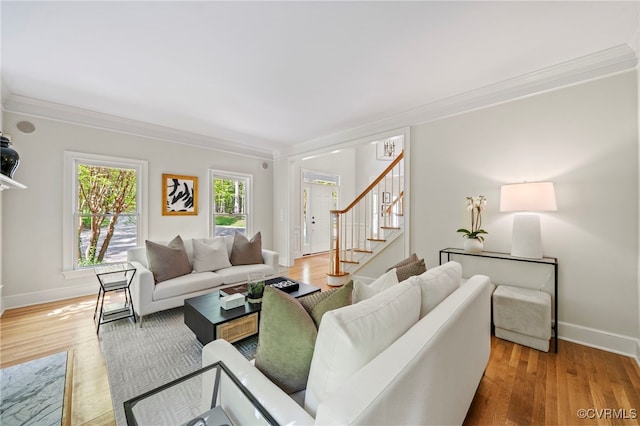 living area featuring stairway, wood finished floors, and crown molding