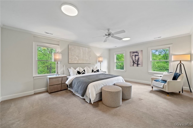 carpeted bedroom featuring baseboards, a ceiling fan, visible vents, and crown molding