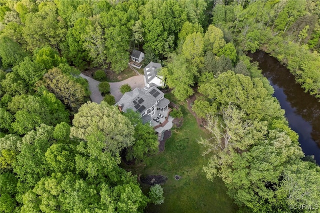 drone / aerial view featuring a water view and a forest view