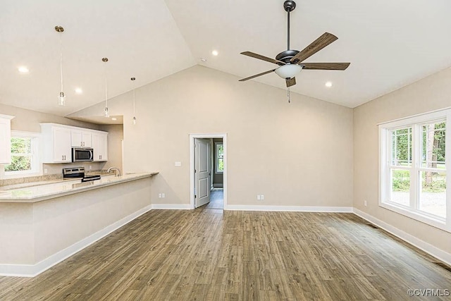 unfurnished living room featuring ceiling fan, wood-type flooring, sink, and high vaulted ceiling