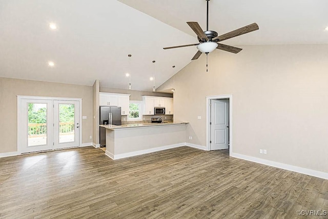 kitchen featuring white cabinetry, decorative light fixtures, appliances with stainless steel finishes, dark hardwood / wood-style floors, and kitchen peninsula