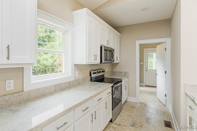 kitchen with light stone countertops, white cabinets, and appliances with stainless steel finishes