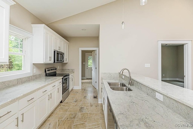 kitchen with light stone countertops, appliances with stainless steel finishes, sink, and white cabinets