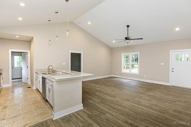 kitchen featuring a wealth of natural light, white cabinetry, sink, hanging light fixtures, and stainless steel dishwasher