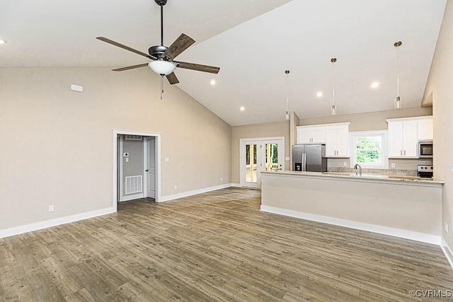 unfurnished living room with high vaulted ceiling, dark hardwood / wood-style floors, ceiling fan, and french doors