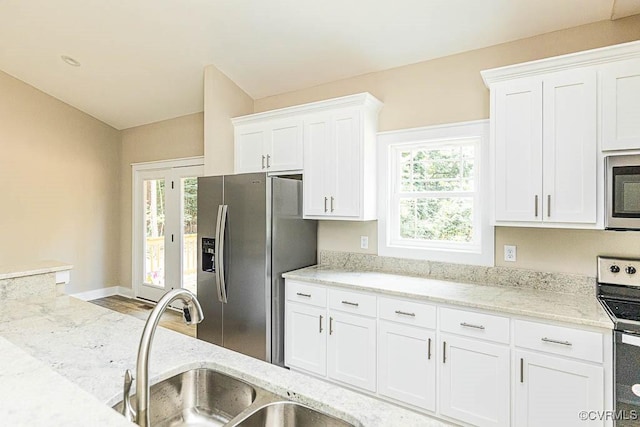 kitchen with sink, stainless steel appliances, white cabinets, and light stone countertops