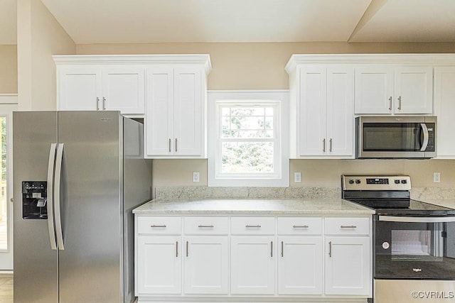 kitchen featuring white cabinetry, light stone countertops, and appliances with stainless steel finishes