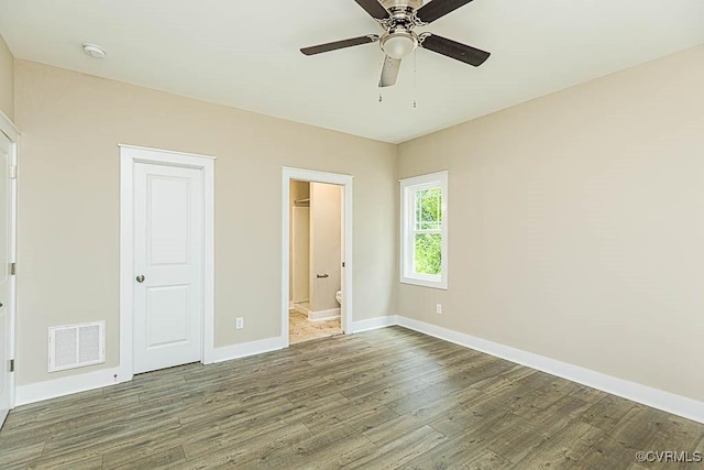 unfurnished bedroom featuring hardwood / wood-style flooring, ceiling fan, and ensuite bathroom