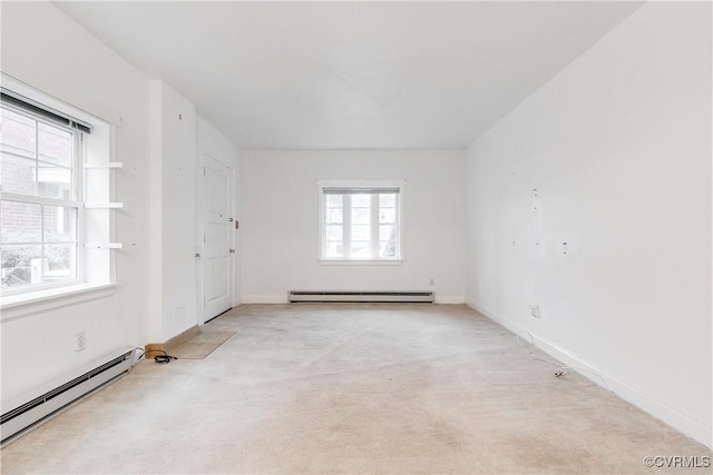 spare room with a baseboard heating unit and light carpet