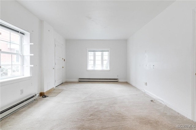 carpeted spare room featuring a baseboard heating unit