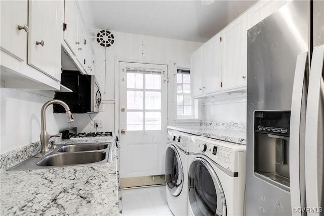 washroom featuring sink, washing machine and dryer, and light tile patterned flooring