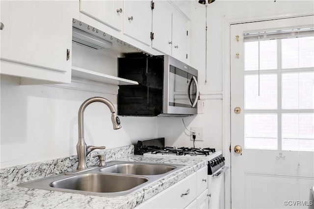 kitchen featuring sink, range with gas cooktop, and white cabinets