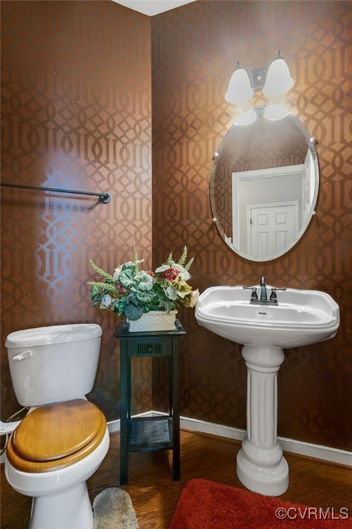 bathroom featuring wood-type flooring and toilet