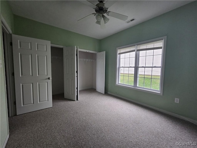 unfurnished bedroom with multiple closets, carpet flooring, and ceiling fan