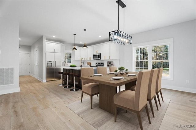 dining space with plenty of natural light and light hardwood / wood-style flooring