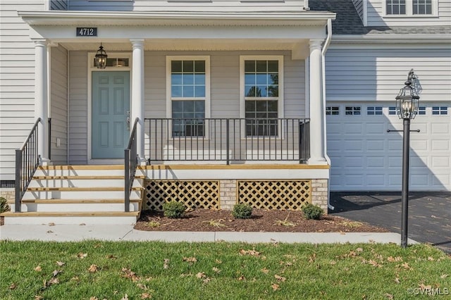 view of exterior entry featuring a garage and covered porch